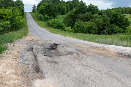 Bad track or road with potholes and faults. Emergency road, dangerous for driversの写真素材