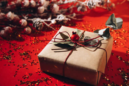 The gift is decorated with dry branches on a red background with gold confetti. Close-upの写真素材