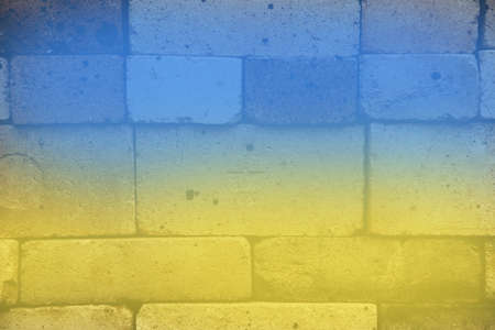 Ukrainian flag blue and yellow on a brick wall. Background of old textured bricks of different shades. Background, textureの写真素材