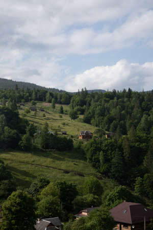 Mountain summer landscape, houses on mountain green hills and blue skyの写真素材