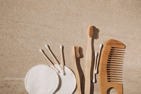 Two wooden toothbrushes, cotton pads and sticks and a wooden hairbrush on a light background. Flat layの写真素材
