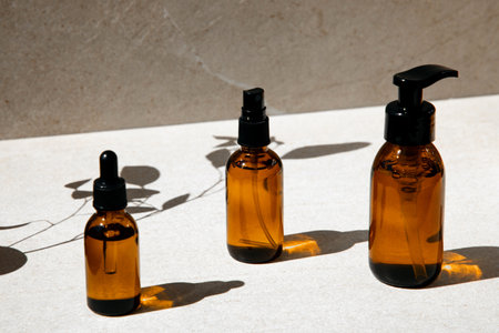 Organic cosmetics, a set of glass bottles with facial cosmetics on a beige background with shadows....
