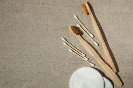 Two wooden toothbrushes, cotton pads and sticks on a light background. Flat layの写真素材