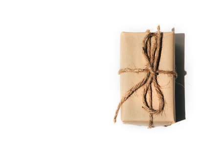 The gift is wrapped in kraft paper and tied with twine on a white background. Top viewの写真素材