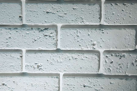 White brick wall background, structural decorative plaster brick. Front view