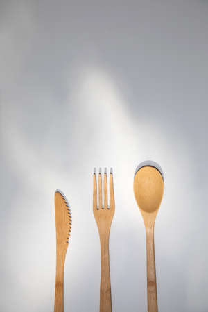 Eco wooden cutlery, spoon, fork, knife on a white background. Top view, copy spaceの写真素材