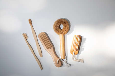 Eco brushes, for nails, washing dishes, toothbrushes with wooden handles on a white background with shadows. Top viewの写真素材