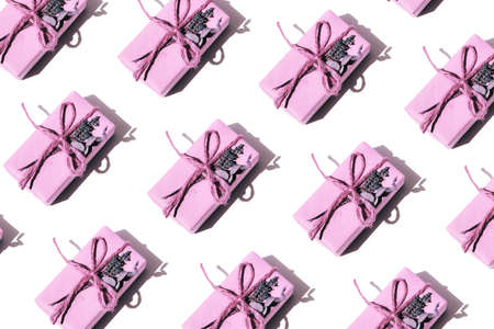 Flat lay pattern of pink gifts in handmade packaging decorated with dry lavender and eucalyptus. Top...