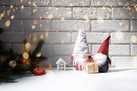 New Year, Christmas background. New Years decor on a white table with branches of a green Christmas tree, pine cones, gnomes. Front viewの写真素材