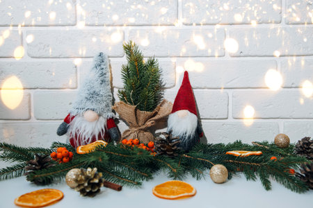 New Year, Christmas background. New Years decor on a white table with branches of a green Christmas tree, pine cones, gnomes. Front viewの写真素材