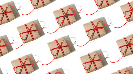 Flat lay pattern of a gift in brown package and red rope, tape with shadow. Web banner