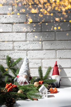New Year, Christmas background. New Years decor on a white table with branches of a green Christmas tree, pine cones, gnomes. Front viewの写真素材
