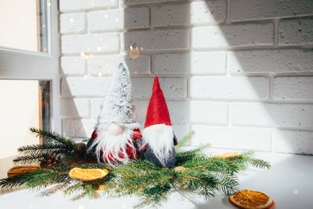 New Year, Christmas background. New Years decor on a white table with branches of a green Christmas tree, pine cones, gnomes. Front viewの写真素材