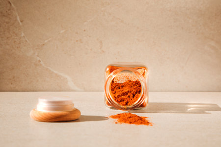 Seasoning in glass jars on a light stone background with shadows. Paprika in open bottle front view, selective focusの写真素材