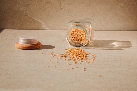 Seasoning mustard in open glass jar on a light stone background with shadows. Front view, selective focusの写真素材
