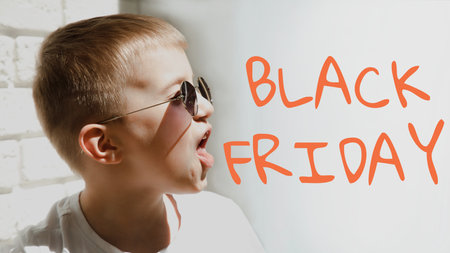 Portrait of a boy in sunglasses grimaces, screaming with sign of black friday. Shopping concept, sale. Front viewの写真素材