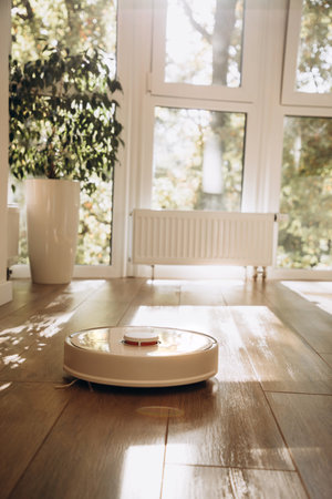 Robot vacuum cleaner does house cleaning close-up. Use of modern technology for cleaning. Front view
