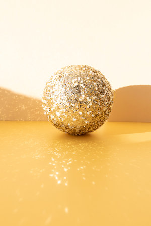 New Year and Christmas background. Christmas golden ball on a yellow background with reflection. Front viewの写真素材