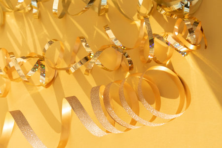 New Year and Christmas background. Golden festival tinsel on a yellow background. Top view