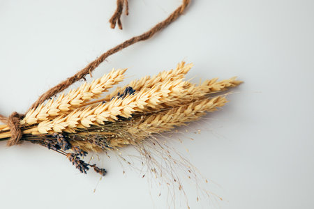 A bouquet of dry spikelets of wheat and lavender tied with a brown rope. View from aboveの写真素材