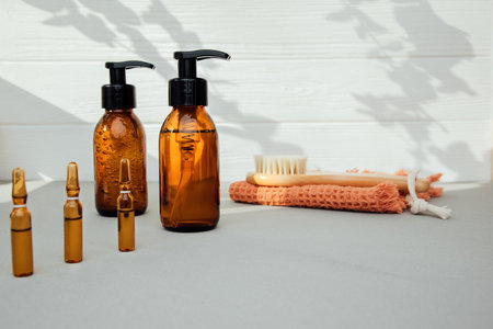 Amber bottles with facial cosmetics with wooden blush and shadows on the concrete-wooden background, bathroom accessories. Front viewの写真素材