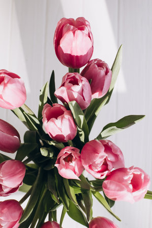 Gently pink bouquet of tulips in a vase. Spring background with a bouquet of flowers. Top viewの写真素材
