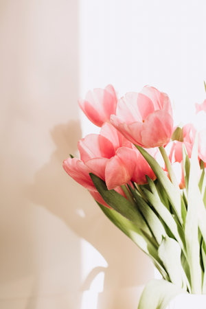 Gently pink bouquet of tulips in a white vase. Spring background with a bouquet of flowers. Front viewの写真素材
