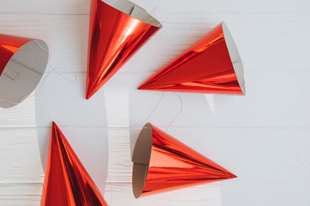 Wooden white background with red cardboard cones for a birthday party. Background for design. Flat...