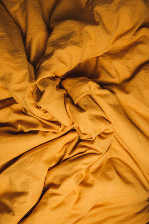 Textured background for design, yellow rumpled fabric. Flat lay, copy spaceの写真素材