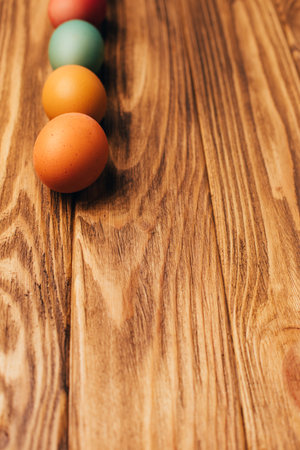 Colored eggs of different sizes on a brown wooden background. Symbol of the Easter holiday. Easter background, front viewの写真素材