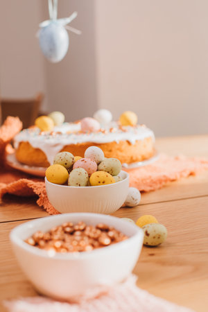 Round Easter cupcake decorated with white protein cream and colorful sprinkles on a wooden table in the kitchen. Front viewの写真素材