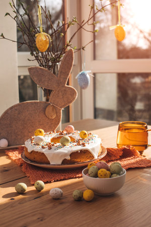 Round Easter cupcake decorated with white protein cream and colorful sprinkles on a wooden table in the kitchen. Front viewの写真素材