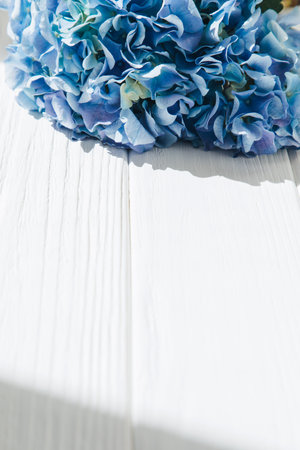 Blue hydrangea on a white wooden table. Flowers background, close-up. Top viewの写真素材
