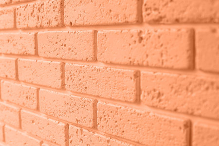 Background of brick wall orange colour, structural decorative plaster brick. Front view