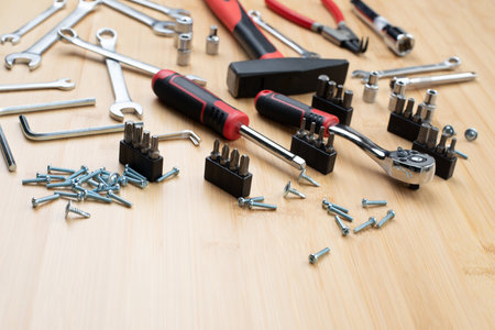 A set of working tools, a hammer, a screwdriver, sockets for repair on a bamboo, wooden background....