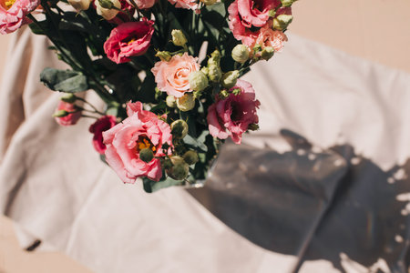 Gently pink eustomas on the beige background. Natural background with a bouquet of flowers with copy space. Flat layの写真素材