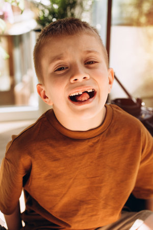 A school age boy shows the teeth that grow after the loss of milk teeth. Close-up portrait. Front viewの写真素材