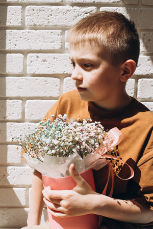 In boys hands bouquet of dry multicolored flowers close-up in pink round box. Gift from boy. Front viewの写真素材