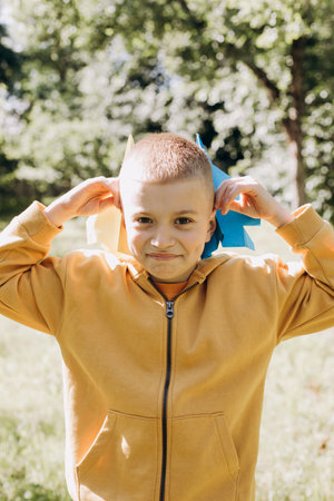 Family picnic. A boy in a green garden in sunny weather on a picnic playing with a paper airplanes....