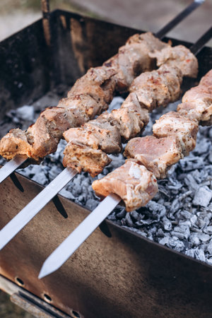 Preparing a barbecue on skewers are fried on the grill. Meat on the fire. Cooking in nature, cook grilled meat on a spit. Top viewの写真素材