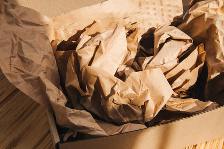 Packaging of eco-materials. Cardboard box and packaging paper on a light background. Concept saving...