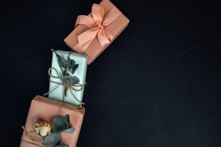 Background for greetings. Gifts wrapping in soft pink and blue paper with dry eucalyptus branch on a...