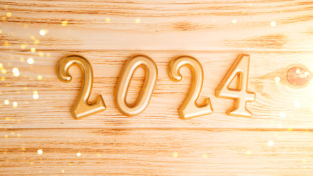 Background for greetings with empty space. Happy new year card. Figures 2024 on a light wooden...