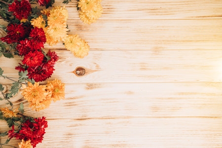 Floral background. Yellow and red chrysanthemums on a light wooden background. A bright bouquet of autumn flowers. Front viewの写真素材