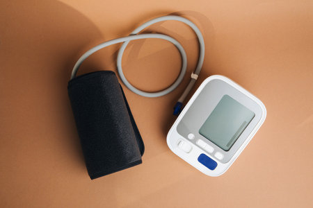 Electronic tonometer to measure blood pressure on a brown background. Top view