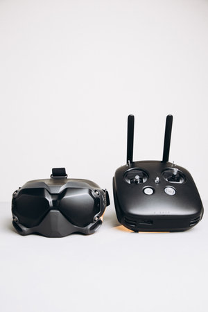 Close-up of black virtual reality glasses and remote control panel on a white background. Glasses...