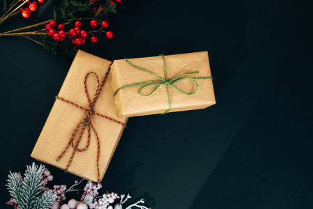 Greeting Christmas background. Gifts wrapping in brown paper on a black background. Front viewの写真素材
