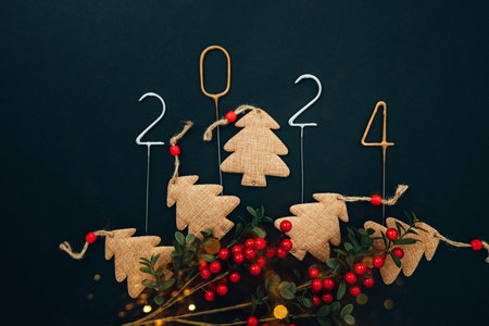 New Year, Christmas background. Candle numbers 2024 in silver and gold on a black background with decorative Christmas trees. Top viewの写真素材