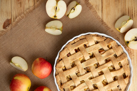 Apple pie in blue form on a light wooden background with a beige kitchen towel. Ready pie. Top viewの写真素材