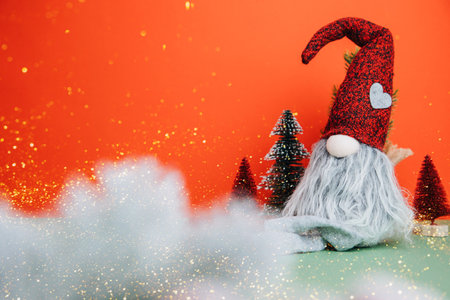 Christmas background for greetings. Christmas trees and gnome on a red-green background. Front view